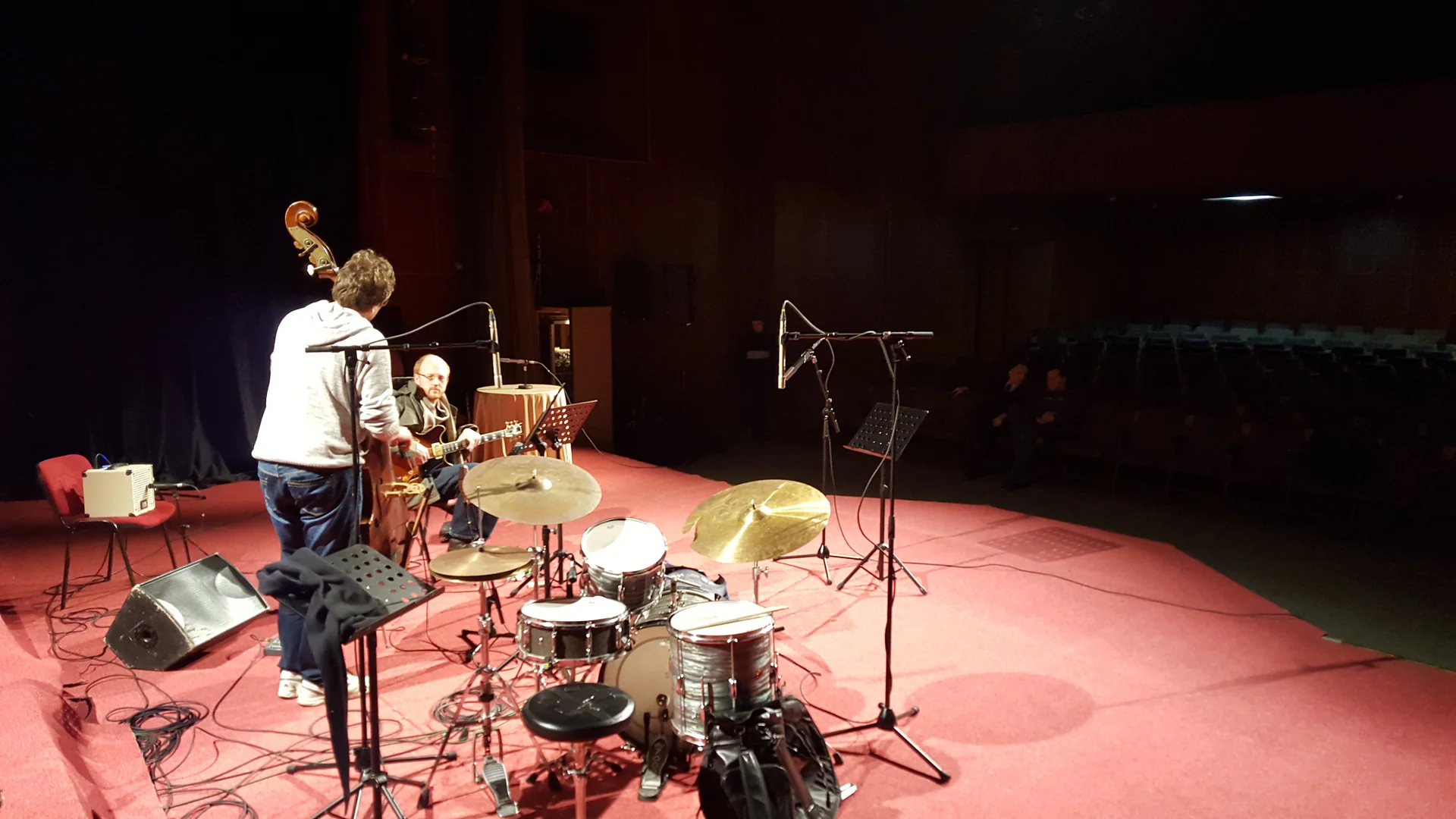 Musicians, a drum kit and microphones on a concert stage