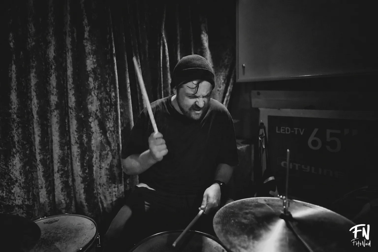 Markus Zink playing drums in a plain black T-shirt