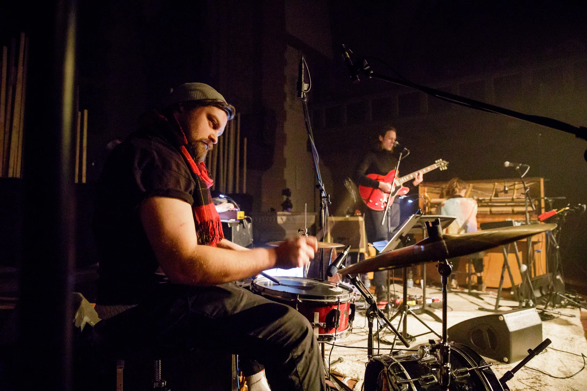 Markus Zink playing drums with a guitarist in the background