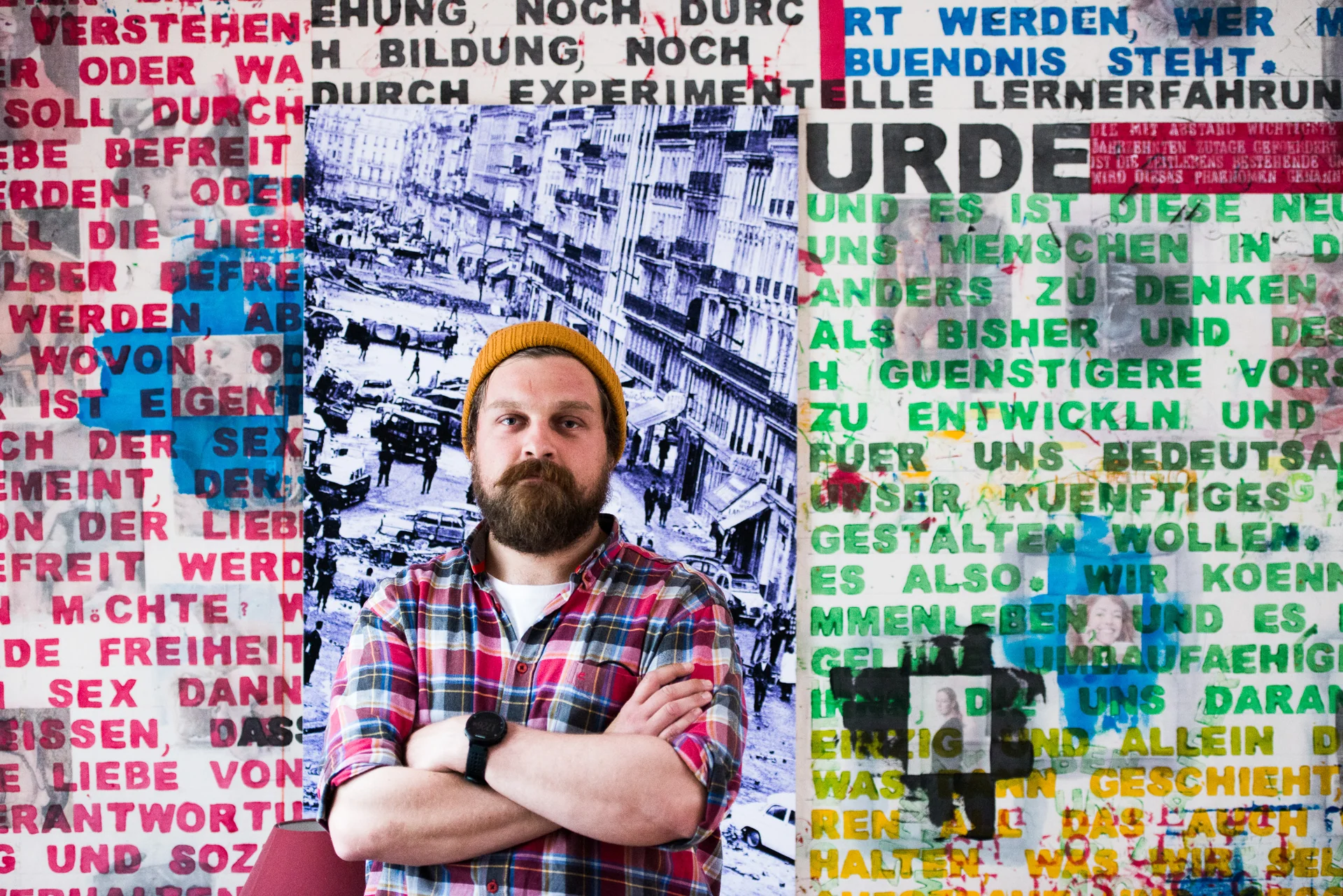 Markus Zink standing with folded arms in front of wall art