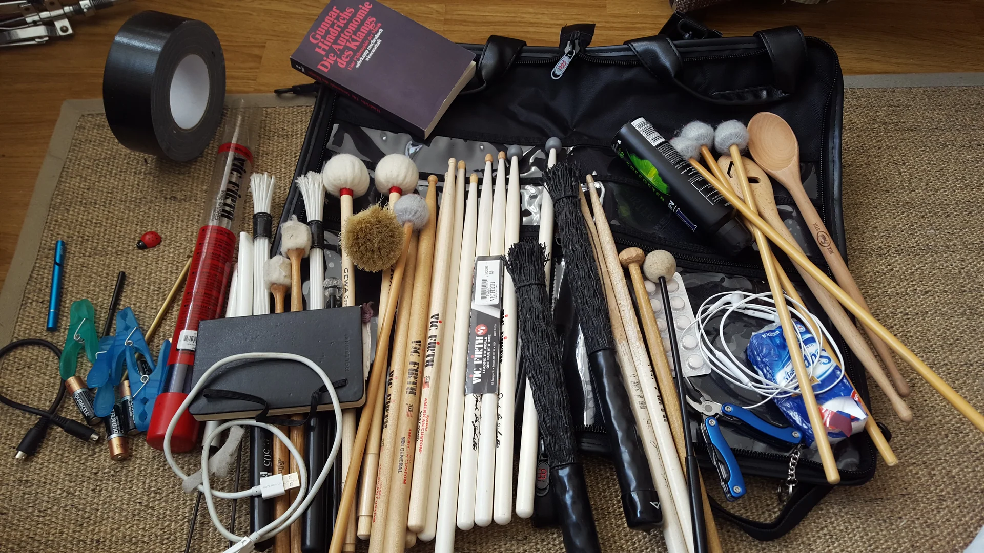 Drumsticks, mallets, brushes and other performance tools in an open bag